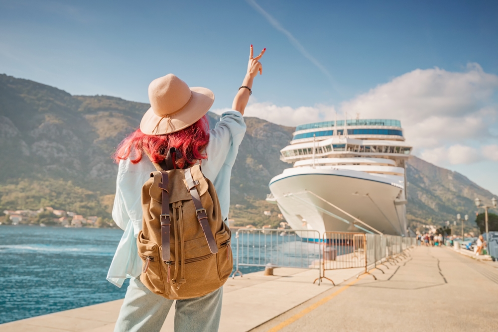 Tourist,Wearing,Backpack,And,Hat,Gesturing,Near,Cruise,Ship,At